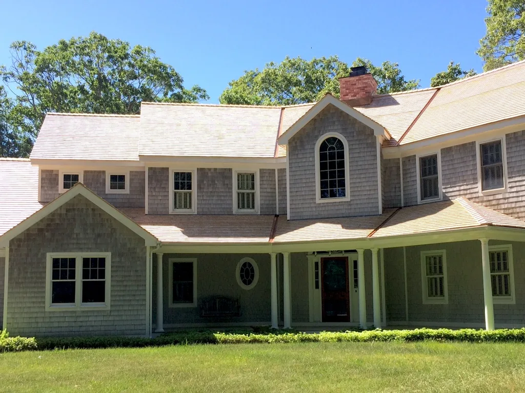 New cedar shake roofing on a two story colonial house with a front porch
