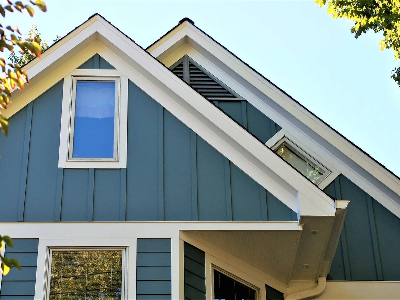 Blue board and batten fiber cement siding on two gables over lap siding