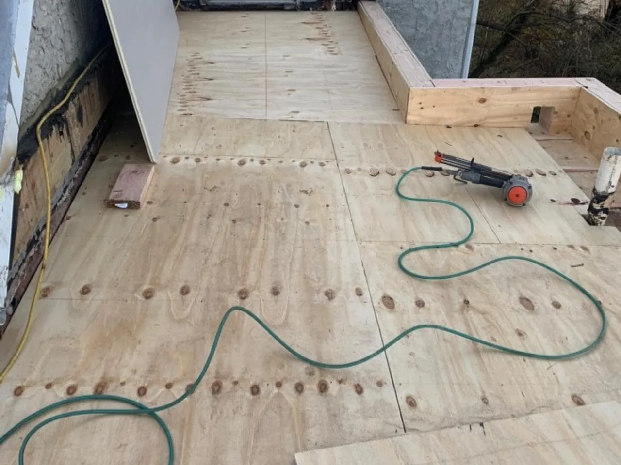 New plywood decking laid on a flat roof area during a flat roofing repair