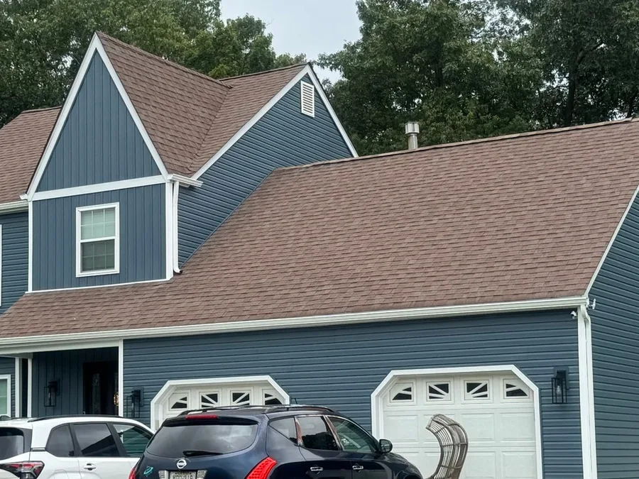 New blue lap siding and white trim on the garage side of a two story home, siding