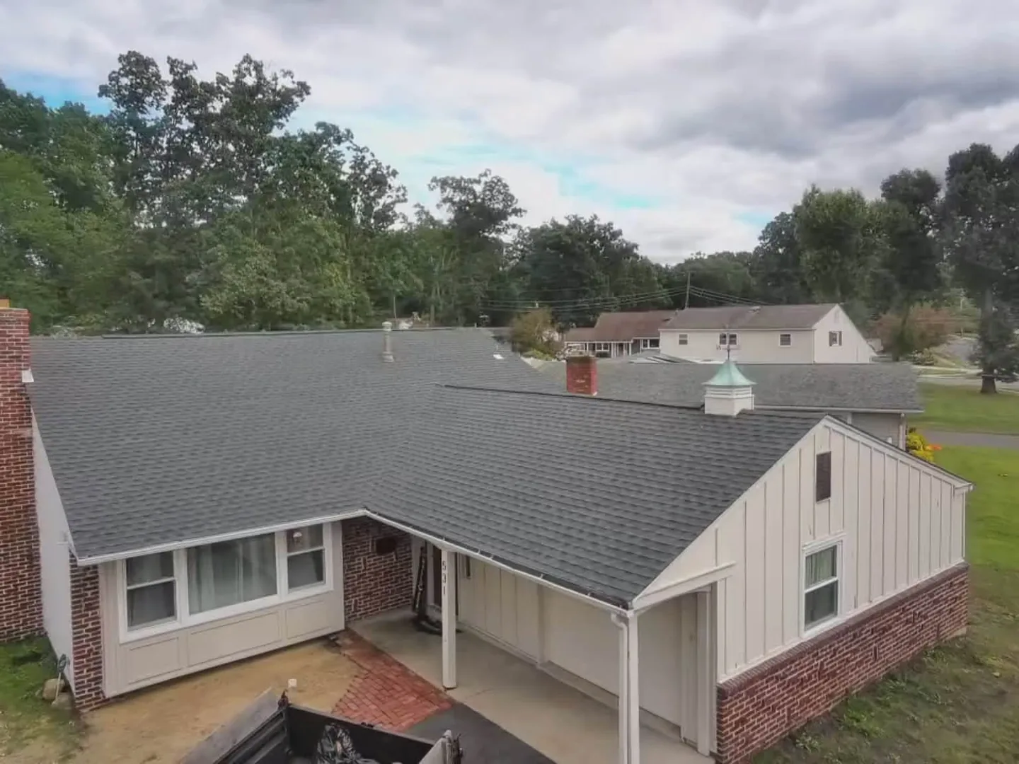 New charcoal asphalt shingle roof on a brick ranch home with a cupola, roof replacement