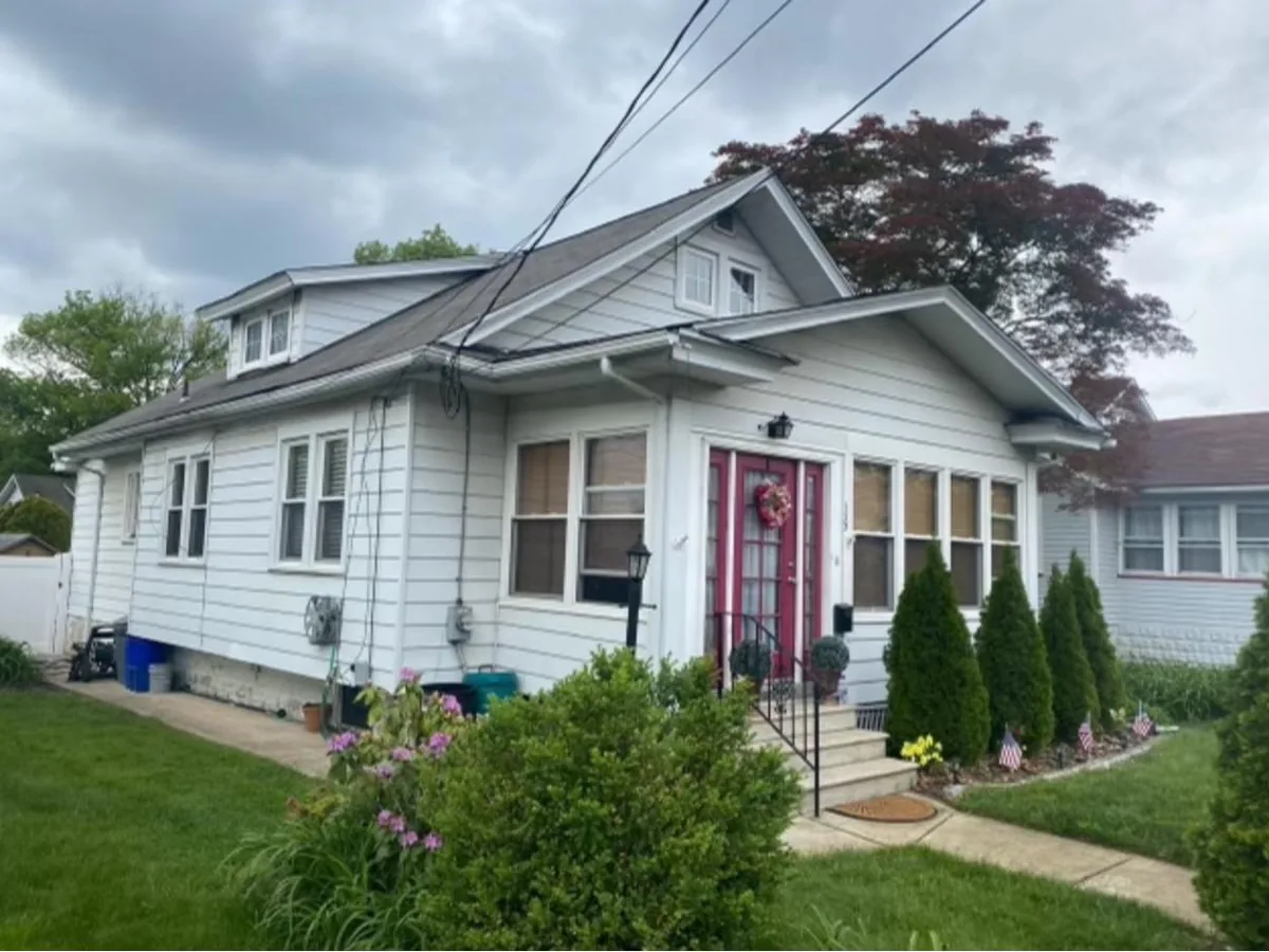 Bungalow with new Pacific Blue vinyl siding, white trim and a red front door, vinyl siding