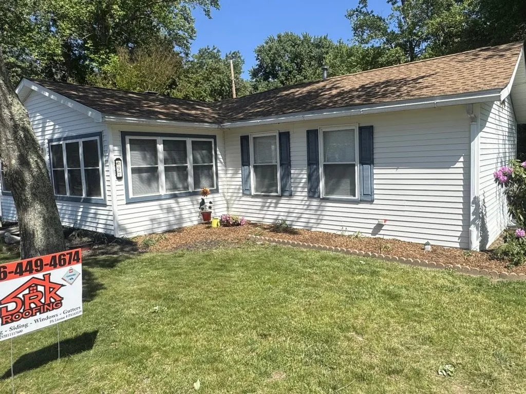 Ranch home with a new Shakewood asphalt shingle roof and a company yard sign, roof replacement