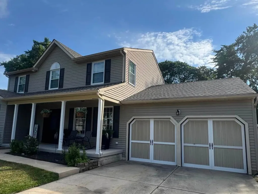 Front porch and two car garage under a new asphalt shingle roof, roof replacement