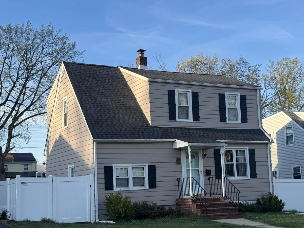 Cape home with a new Appalachian Sky asphalt shingle roof and tan siding, roof replacement