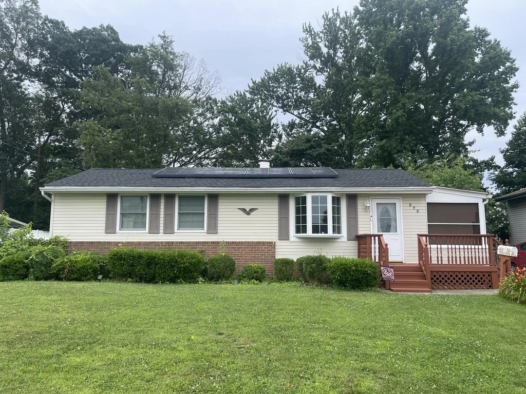 New seamless gutters along the eave of a ranch home with a new roof, gutter installation