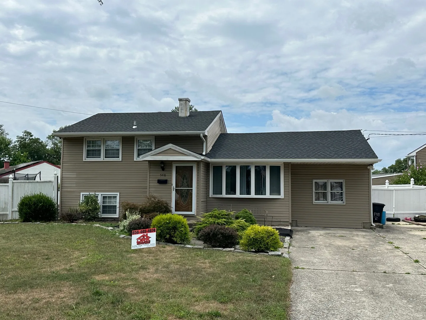 New white gutters and downspouts on a split level home, gutter installation