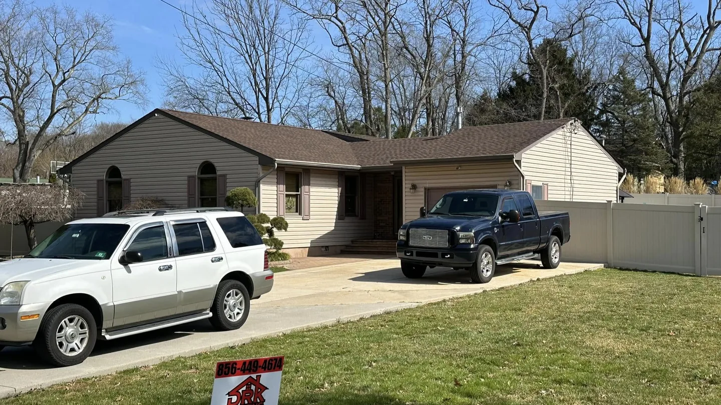 Ranch home with a new roof and a yard sign on the lawn