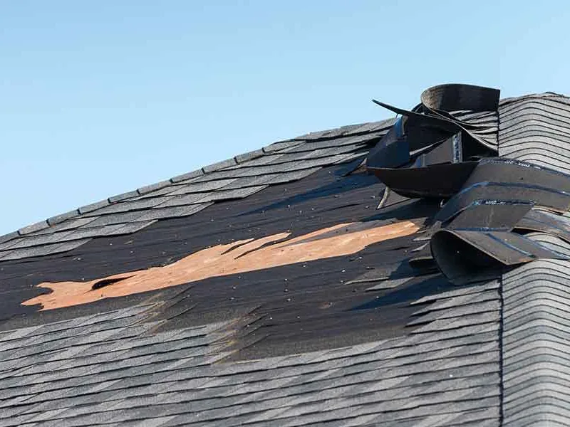 Missing and lifted shingles exposing the roof deck on a hip roof, roof repair