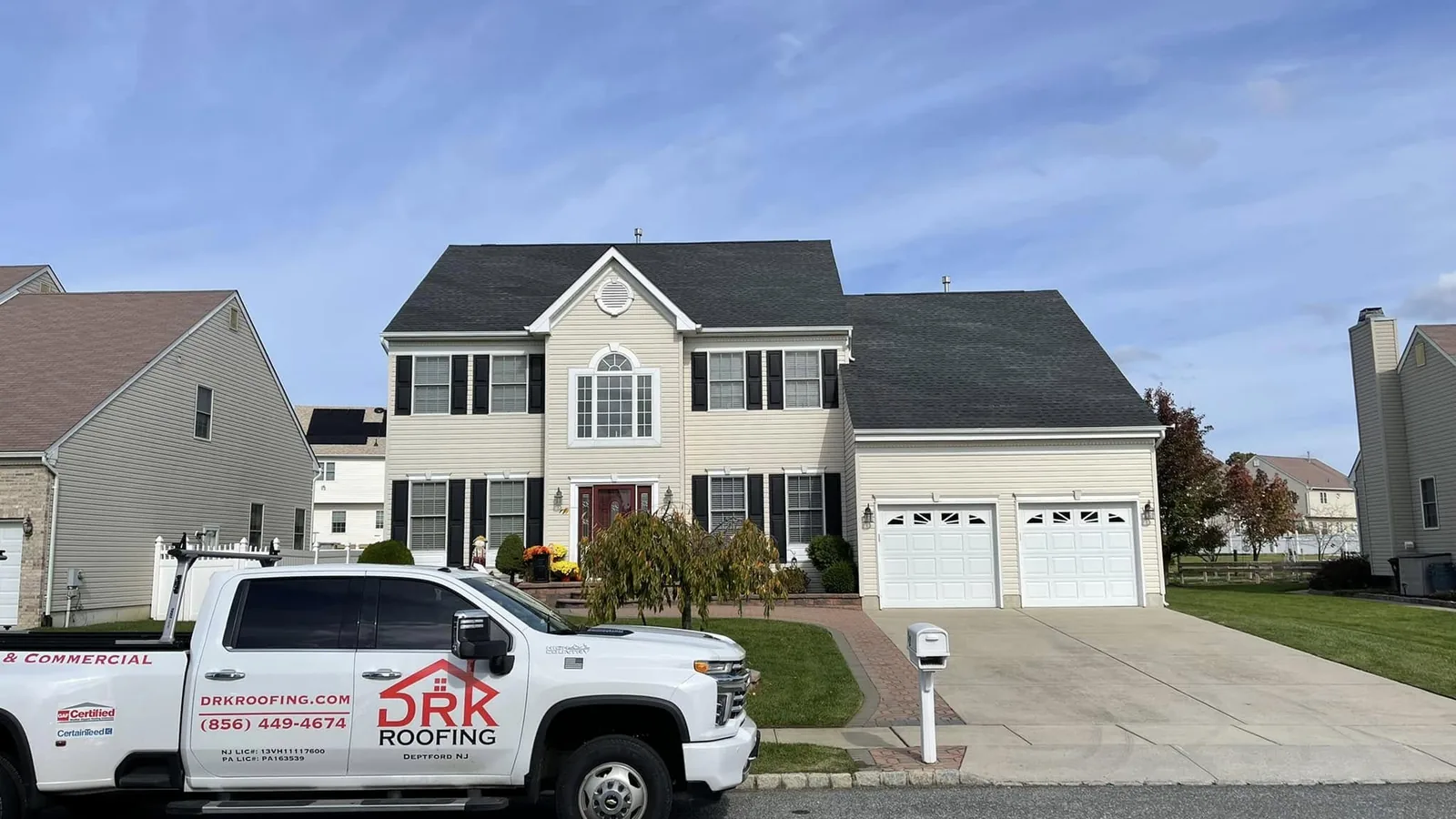 Roofing contractor pickup truck parked in front of a two story home