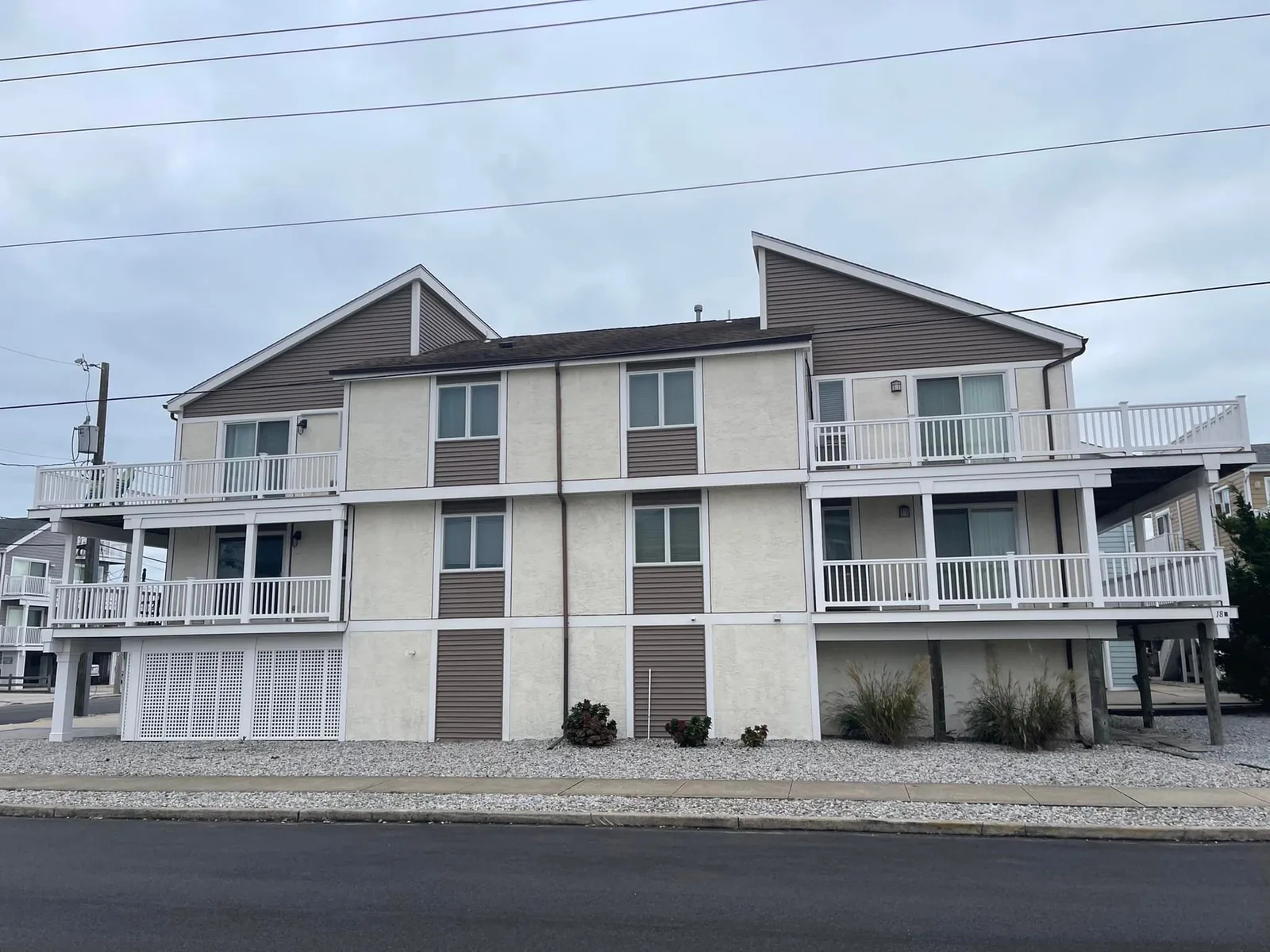 New siding on a three story shore house with white deck railings, siding contractor