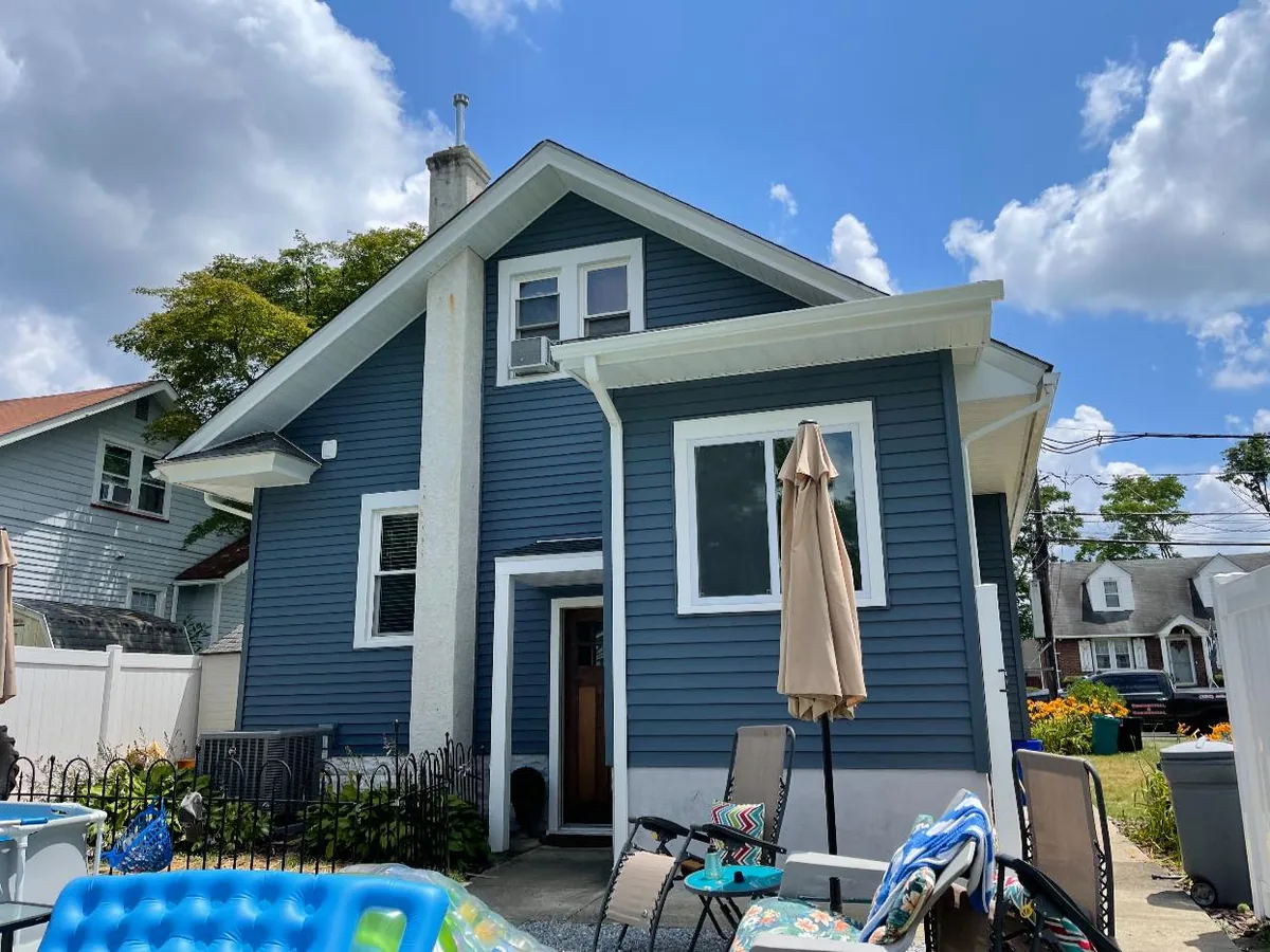 Blue vinyl siding with white trim on a small two story home