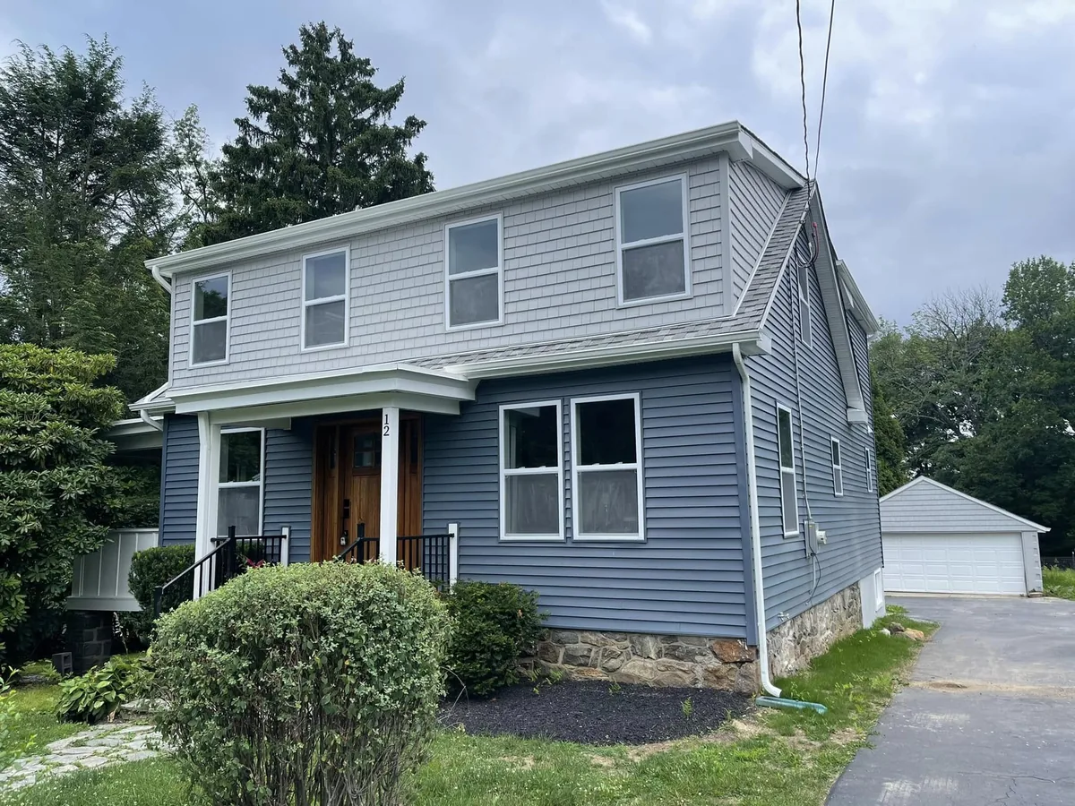 Blue gray vinyl siding with white trim on a two story home