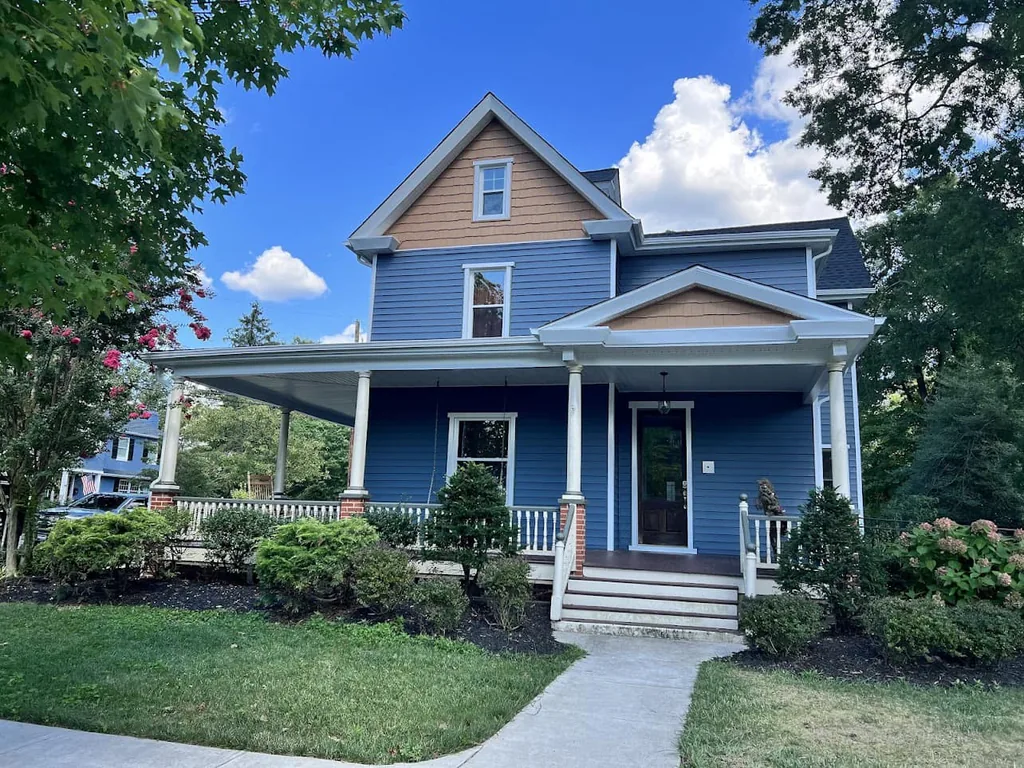 Two story home with new windows, new siding and a front porch, window replacement